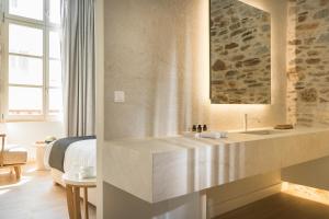 a hotel room with a sink and a bed at SYROS SOUL LUXURY SUITES in Ermoupoli +37 photos