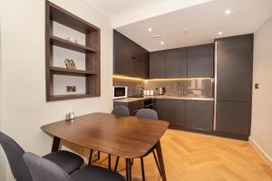 una cucina e una sala da pranzo con tavolo e sedie in legno di City Apartments - Hudson Quarter a York