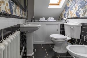 a bathroom with a white toilet and a sink at Sage Cottage in Atworth