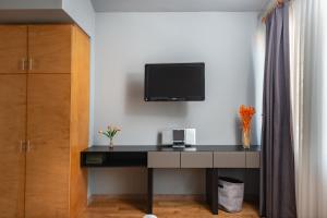 einen Schreibtisch in einem Zimmer mit einem TV an der Wand in der Unterkunft Mayer Loft Suites in Istanbul