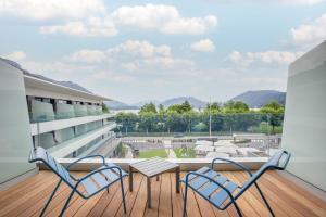 a balcony with two chairs and a table on a building at Rivage Hôtel & Spa Annecy in Annecy
