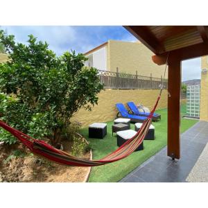 a hammock and chairs in a yard at Casa Miradouro do Moinho in Porto Santo