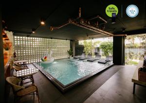 einen Pool mit Stühlen und eine Treppe in einem Haus in der Unterkunft the echo hotel in Chiang Mai