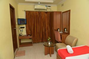a hotel room with a bed and a couch and a television at Hotel Sonas in Tiruchchirāppalli