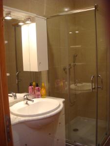 a bathroom with a sink and a glass shower at Casa De Hospedes Flor Do Jardim in Malveira