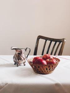 a basket of apples and a pitcher on a table at Villa Rosa in Bad Gastein