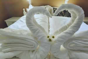 a bed with white towels in the shape of a heart at BanPim Beachside Lofoten in Ramberg