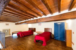 a room with two red chairs and a wooden ceiling at Casale Vacanze Il Granaio in Cortona
