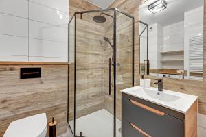 La salle de bains est pourvue d'une douche et d'un lavabo. dans l'établissement Angielska Grobla 5 Apartinfo Apartments, à Gdańsk