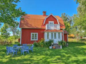 ein rotes Haus mit einem Tisch und Stühlen im Hof in der Unterkunft Lunden in Släthult