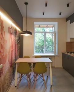 eine Küche mit einem Tisch, 2 Stühlen und einem Fenster in der Unterkunft Nice and plesant apartments on Evropeyska st. in Poltawa