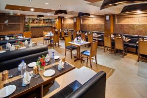 a restaurant with a large kitchen with tables and chairs at Coraltree By Goldfinch Hotels Bangalore in Bangalore