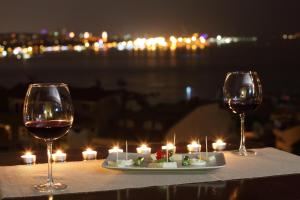 two glasses of wine sitting on a table with candles at Lir Residence Suites LONG STAY in Istanbul