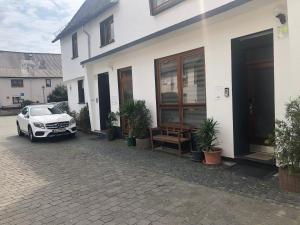 a white car parked in front of a house at Seven’S Apartments in Löhnberg