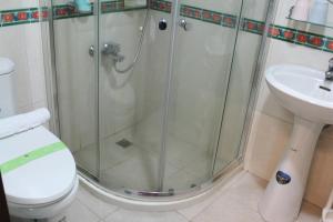 y baño con ducha, aseo y lavamanos. en PianoPiano B&B, en Jincheng