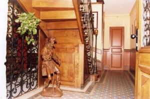 a statue of a man standing next to a wooden door at Hôtel De La Ferté in Chagny