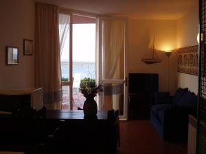 a living room with a table and a view of the ocean at Rocca Ruja Vip in Stintino