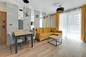 Angielska Grobla 5 Apartinfo Apartments في غدانسك: غرفة معيشة مع أريكة وطاولة