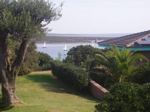 a garden with a view of the water with sailboats at Rocca Ruja Vip in Stintino