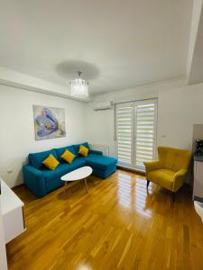a living room with a blue couch and a table at Apartman M&M in Doboj