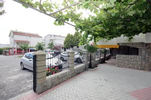 a fence with a car parked next to a street at Apartments Kojic in Bar
