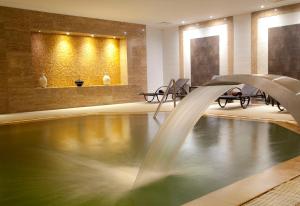 a swimming pool with a fountain in a hotel lobby at Ikbal Thermal Hotel & Spa Afyon in Afyon