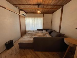 a bed in a room with a couch and a table at WhyKumano UNWINED in Nachikatsuura