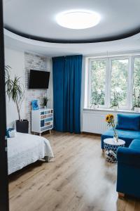um quarto com cortinas azuis, uma cama e um sofá em Apartament Blue em Lublin