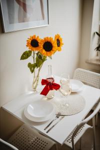 uma mesa com pratos e um vaso com girassóis em Apartament Blue em Lublin