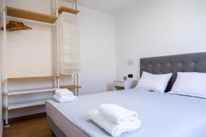 een slaapkamer met een wit bed en handdoeken bij Holiday Houses Portoroz in Portorož