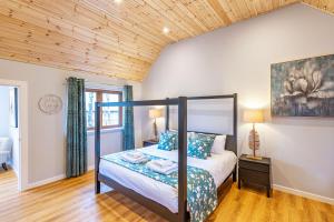 a bedroom with a canopy bed in a room at Thistle Lodge 22 with Hot Tub in Belladrum
