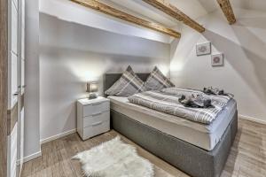 a bedroom with a bed with a night stand and a rug at Ferienhaus Leutner in Bodenmais