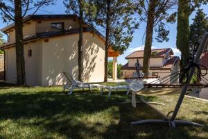 een groep stoelen in een tuin met een huis bij Holiday Houses Portoroz in Portorož