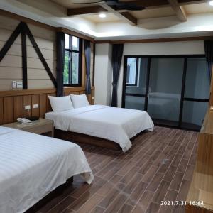 a hotel room with two beds and windows at Gaodiyuan Tea B&B 高帝園茶業民宿 in Meishan