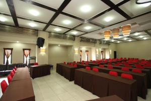 a lecture hall with red chairs and tables and lights at Sanur Agung Hotel in Sanur