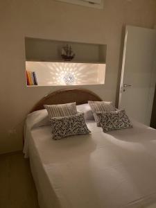een groot wit bed met 2 kussens erop bij Casa Alfonsa in Villanova di Ostuni