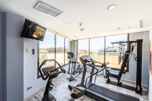 a gym with two treadmills and two ellipticals at Hotel Valencia Oceanic Affiliated by Meliá in Valencia