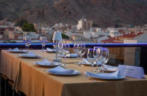 a table with wine glasses and napkins and a view at Hotel Julián in Alhama de Murcia