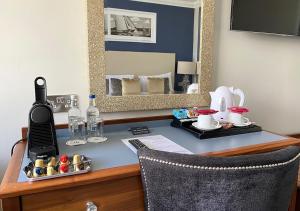 a desk in a hotel room with a phone and a mirror at Haven Hotel in Poole