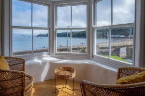 a room with windows with a view of the ocean at Brook Cottage - 7 Bedroom Cottage - Dale in Dale