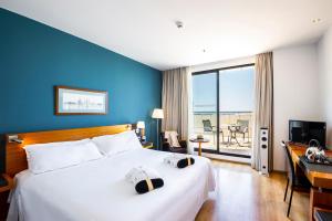 a hotel room with a bed and a desk and a window at Hotel Valencia Oceanic Affiliated by Meliá in Valencia