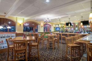 a restaurant with tables and chairs and a bar at Super 8 by Wyndham Erie/I 90 in Erie
