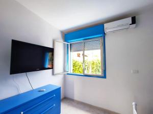 ブルコリにあるAl Meriggio Apartmentsの青いドレッサーと窓が備わる客室です。