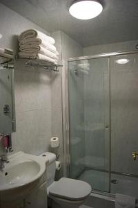 a bathroom with a shower and a toilet and a sink at Westpoint Hotel in London