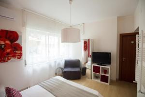 ナポリにあるBernini 20のベッドルーム(ベッド1台、椅子、テレビ付)