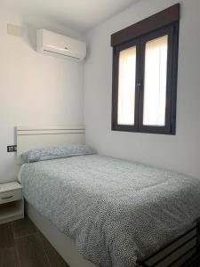Un dormitorio blanco con una cama y una ventana. en La fuentenita, en Santa Cruz de Paniagua