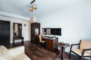 a living room with a couch and a desk in a room at Dwór Dwikozy in Sandomierz