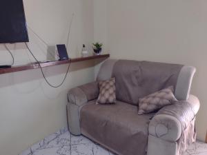 a brown couch sitting in a living room at Sobrado aconchegante in Ilhéus