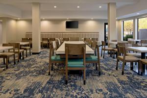 a dining room with tables and chairs and a flat screen tv at Best Western Valencia/Six Flags Inn & Suites in Santa Clarita