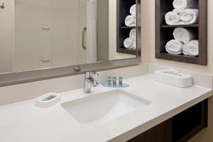 a bathroom with a sink and a mirror and towels at Best Western Valencia/Six Flags Inn & Suites in Santa Clarita